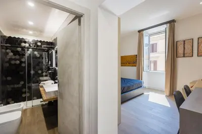 a bathroom with a shower and a sink and a bed at KOSMO ROME Luxury in Rome