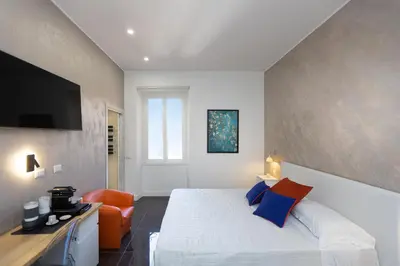 a bedroom with a white bed and a orange chair at KOSMO ROME Luxury in Rome