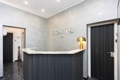 a lobby with a counter with a sign on the wall at KOSMO ROME Luxury in Rome