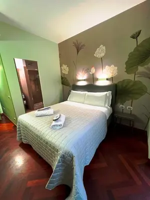 a bedroom with a large bed with flowers on the wall at Dolce Vita Guest House in Rome