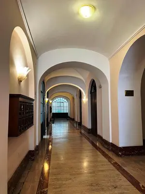 a hallway in a building with white walls and an archway at Dolce Vita Guest House in Rome