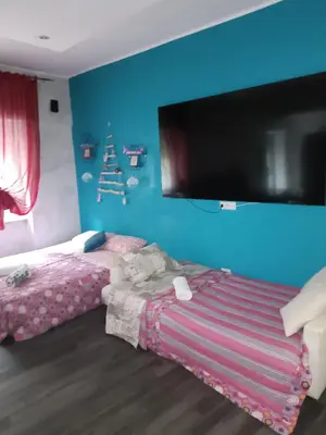 a bedroom with a blue wall with a bed and a flat screen tv at Nathan House,Teano in Rome
