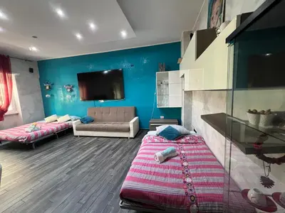 a living room with two beds and a tv on the wall at Nathan House,Teano in Rome