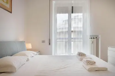 a white bedroom with a bed with towels on it at Appartamento Trastevere & Porta Portese grande in Rome
