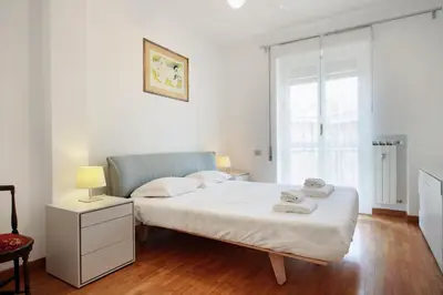 a white bedroom with a bed and a window at Appartamento Trastevere & Porta Portese grande in Rome