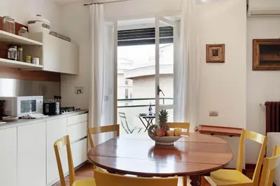 a kitchen and dining room with a wooden table and chairs at Appartamento Trastevere & Porta Portese grande in Rome