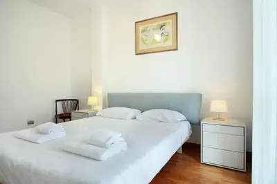 a bedroom with a white bed with two white towels at Appartamento Trastevere & Porta Portese grande in Rome