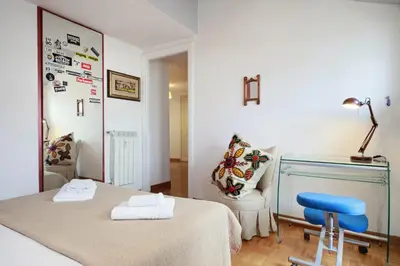 a room with two beds and a blue chair at Appartamento Trastevere & Porta Portese grande in Rome