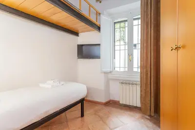 a small bedroom with a bed and a window at Barberini 3 BDR Apartment in Rome