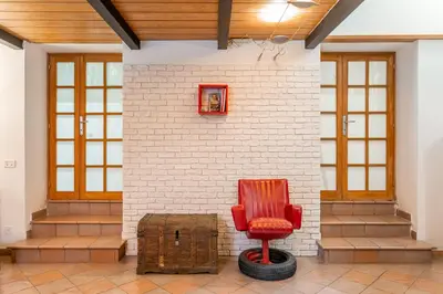 a red chair sitting in a room with a brick wall at Trastevere Vintage Artistic Loft in Rome