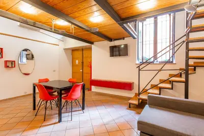 a room with a table and chairs and a staircase at Trastevere Vintage Artistic Loft in Rome