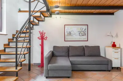 a living room with a couch and a staircase at Trastevere Vintage Artistic Loft in Rome