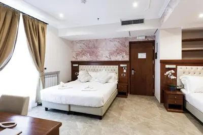 a bedroom with two beds and a desk and a table at Esposizione Luxury Rome in Rome