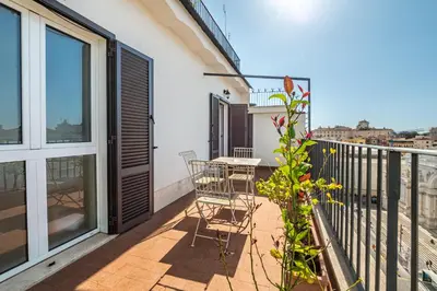 a balcony with a table and chairs on it at Esposizione Luxury Rome in Rome