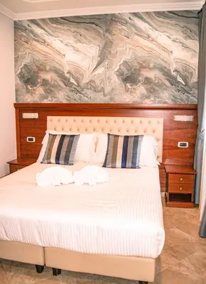 a bedroom with a bed with a painting on the wall at Esposizione Luxury Rome in Rome