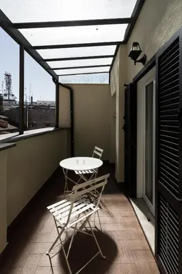 a patio with a table and chairs on a balcony at Esposizione Luxury Rome in Rome