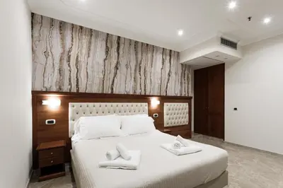 a bedroom with a large white bed with towels on it at Esposizione Luxury Rome in Rome