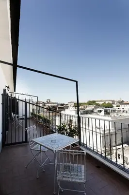 a patio with a table and chairs on a balcony at Esposizione Luxury Rome in Rome