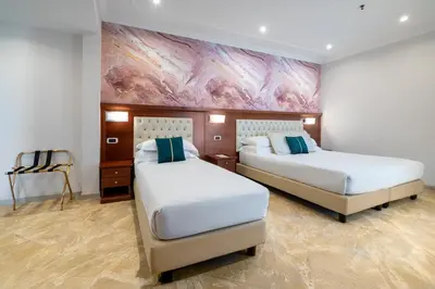 two beds in a room with a painting on the wall at Esposizione Luxury Rome in Rome