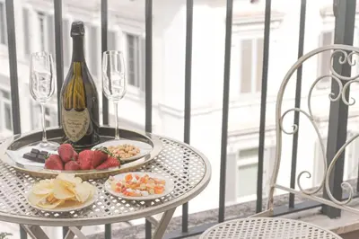 a table with a bottle of champagne and a plate of food at Esposizione Luxury Rome in Rome