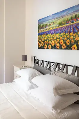 a bedroom with a painting of a field of flowers at R.C. Cappellari Loft Campo de' Fiori in Rome