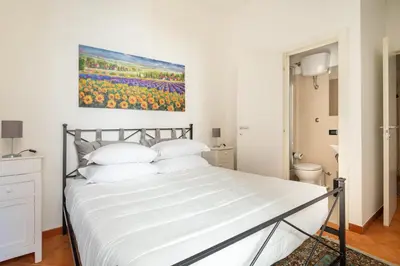 a bedroom with a white bed with a painting on the wall at R.C. Cappellari Loft Campo de' Fiori in Rome