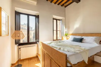 a bedroom with a large bed and windows at iFlat Lovely flat in Navona in Rome