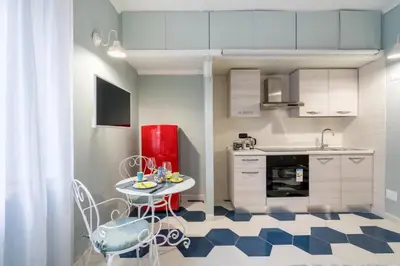 a kitchen with a small table and a red refrigerator at The small nest at Coliseum in Rome
