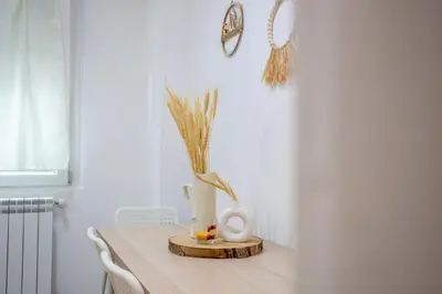 a table with a vase and flowers on it at Holiday Homes Rome - Portuense 21 - Family Studio in Rome