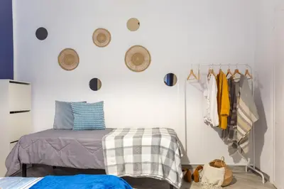 a bedroom with a bed and a rack of clothes at Holiday Homes Rome - Portuense 21 - Family Studio in Rome