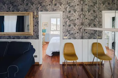 a bedroom with a bed and two chairs and a mirror at New opening San Pietro roof apartament in Rome