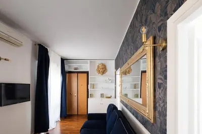 a living room with a blue couch and a mirror at New opening San Pietro roof apartament in Rome