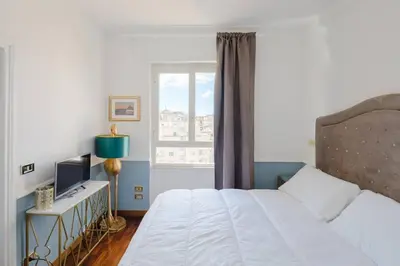 a bedroom with a white bed and a window at New opening San Pietro roof apartament in Rome