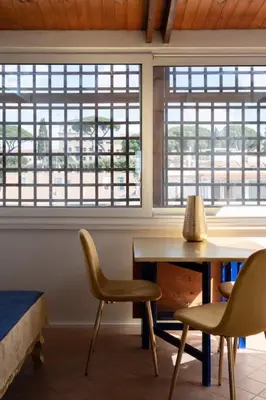 a room with a table and chairs and windows at New opening San Pietro roof apartament in Rome