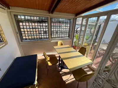 a table and chairs in a room with a balcony at New opening San Pietro roof apartament in Rome