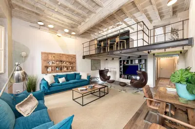 a living room with a blue couch and a table at Design apt near Spanish Step in Rome