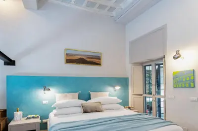 a bedroom with a bed with a blue wall at Design apt near Spanish Step in Rome