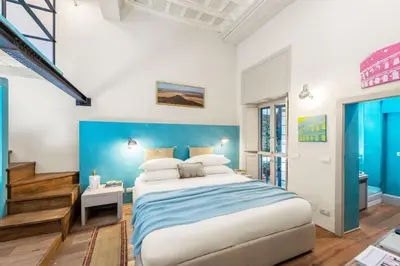 a bedroom with a large bed with a blue wall at Design apt near Spanish Step in Rome