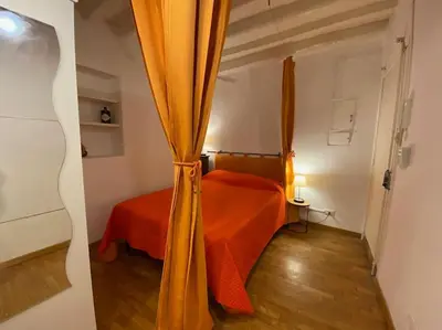a bedroom with a bed with an orange curtain at Casa Uberto in Rome