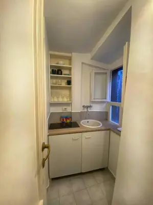 a white bathroom with a sink and a window at Casa Uberto in Rome
