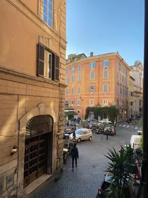 a group of people walking down a street next to a building at Casa Uberto in Rome
