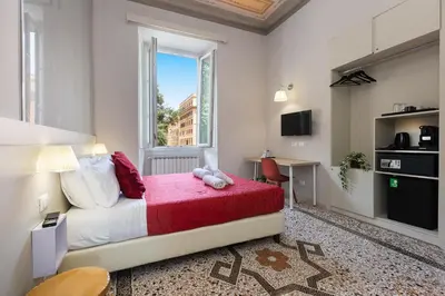 a bedroom with a bed and a window and a desk at Iron Cityaus Termini in Rome