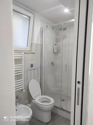 a bathroom with a toilet and a glass shower at Casa Mario in Rome