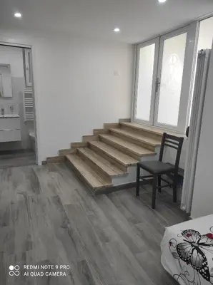 a living room with wooden stairs and a chair at Casa Mario in Rome