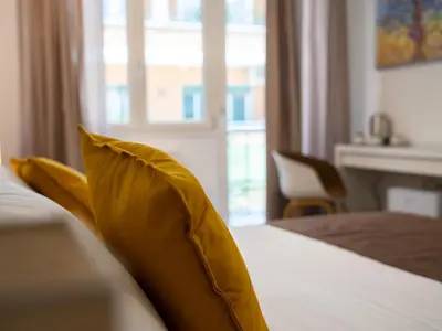 a hotel room with a yellow pillow on a bed at Anastasio Vatican Rooms G H in Rome
