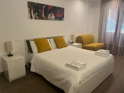 a bedroom with a bed with yellow pillows and a chair at Anastasio Vatican Rooms G H in Rome