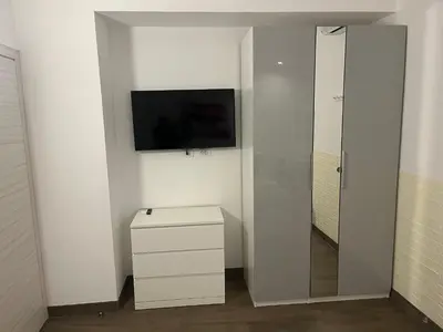 a white room with a television and a white cabinet at Anastasio Vatican Rooms G H in Rome