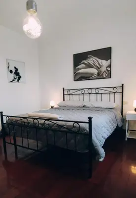 a bedroom with a bed with a black metal frame at l'altra casetta dei Quintili in Rome