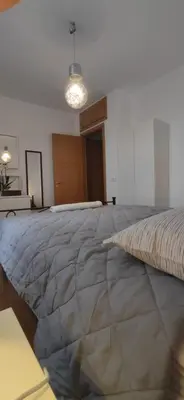 a large bed in a white room with a light at l'altra casetta dei Quintili in Rome
