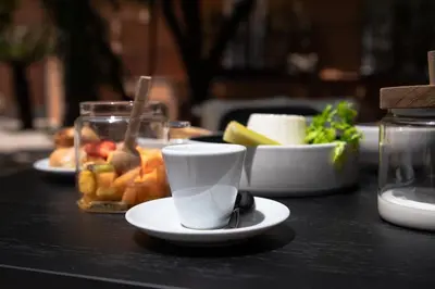a table with a cup and plates of food at The Sanctuary Urban Retreat in Rome